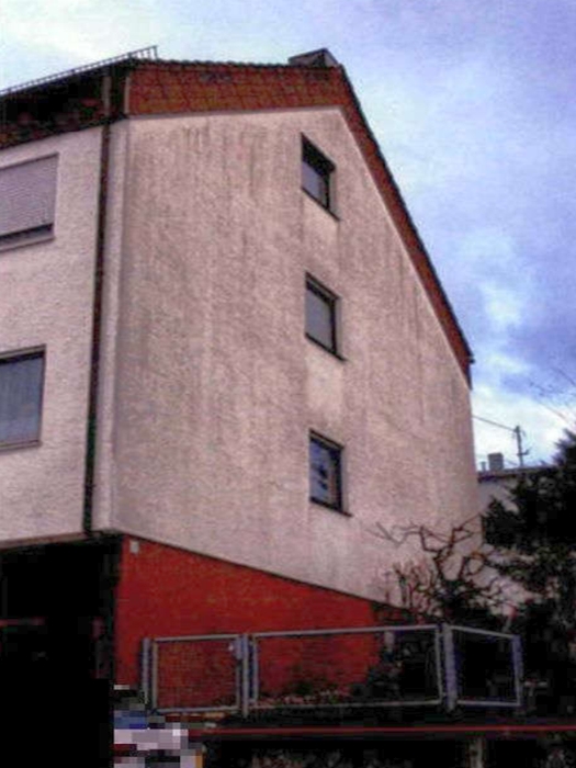 Reihenhaus in Backnang-Steinbach, Pflaster 31/4, mit weißer Fassade, rotem Sockelbereich und Dachgauben unter bewölktem Himmel