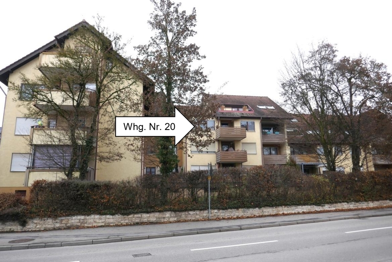 Gebäude in Öhringen, Rendelstraße 23/25, mit markierter Wohnung Nr. 20; mehrstöckige Wohnhäuser mit Balkonen, Bäume und Hecke im Vordergrund, Straße im Vordergrund