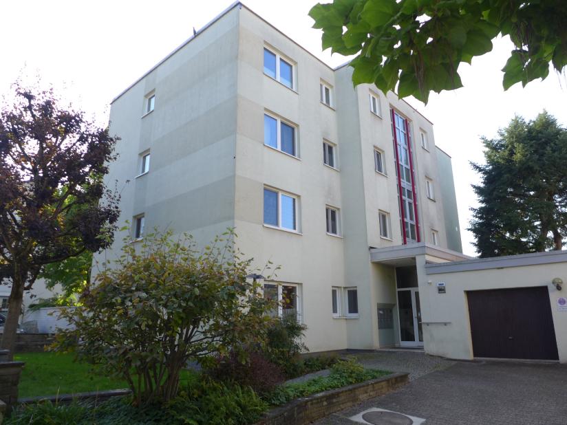 Mehrfamilienhaus mit hellen Fassaden, Fenstern und Eingangsbereich, umgeben von Grünanlagen und Bäumen, Kalbacher Hauptstraße 60 c, Frankfurt am Main
