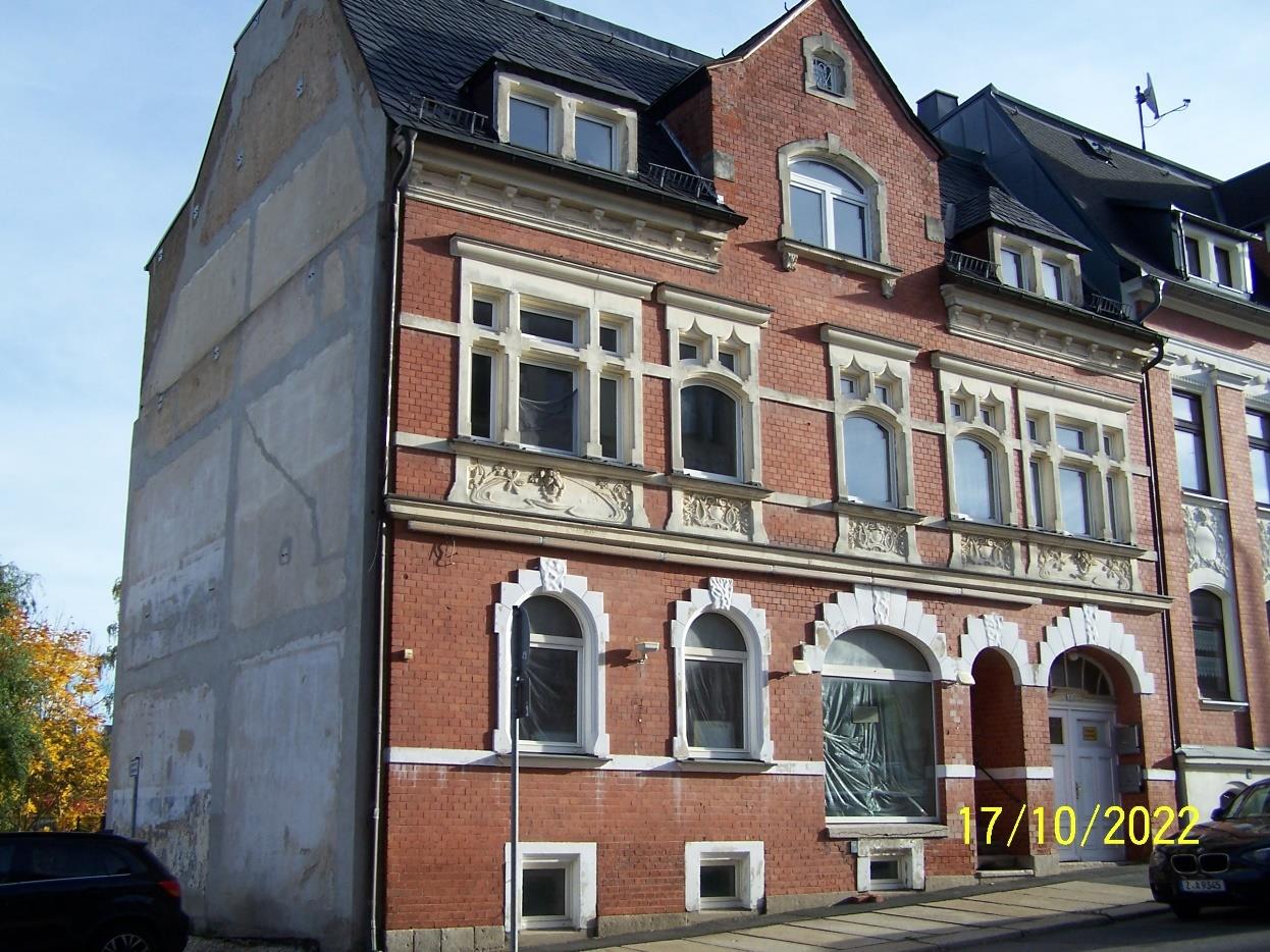 Fassade eines mehrstöckigen Backsteinhauses mit geschwungenen Fenstern und Verzierungen, R.-Breitscheid-Straße 7, Falkenstein