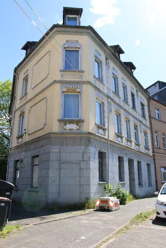 Eckfassade eines Mehrfamilienhauses in Castrop-Rauxel, Altstadtring 143, mit gelbem Putz, grauem Sockel und Fenstern mit Verzierungen