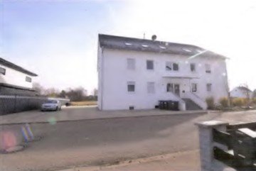 Vorderansicht eines weißen Mehrfamilienhauses in Ellwangen, Ipfstraße 38, mit Eingangstreppe und Fenstern, geparktem Auto vor dem Gebäude