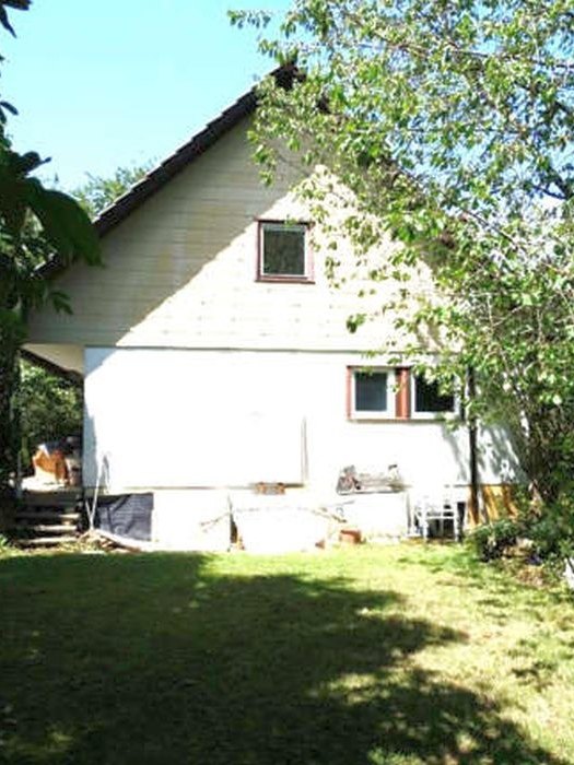 Rückansicht eines zweistöckigen Gebäudes mit hellen Fassaden, Dachgauben und Fenstern, umgeben von Grünfläche und Bäumen in Hildrizhausen, Parkstraße 2
