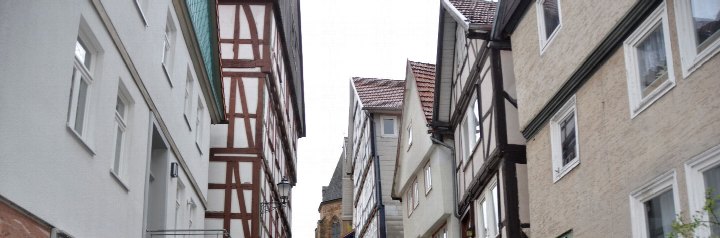 Außenansicht der Kornstraße 12 in Immenhausen, 34376, mit Fachwerkelementen und angrenzenden Gebäuden in einer engen Straße