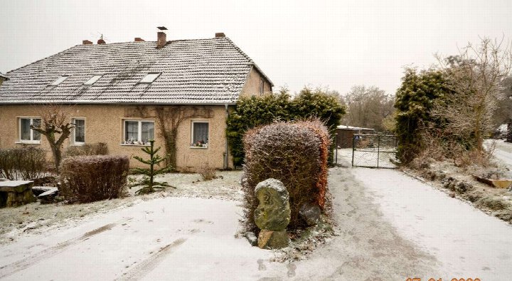 Garten des Einfamilienhauses Am Schmiedeberg 2 in Boitzenburger Land, 17268, mit Schneebedeckung, Hecken, Steinen und Eingangstor