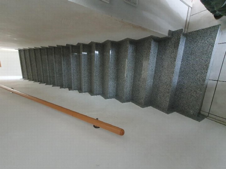 Innenansicht einer Treppe mit Granitstufen und Holzgeländer in einem Wohnhaus in Mechernich