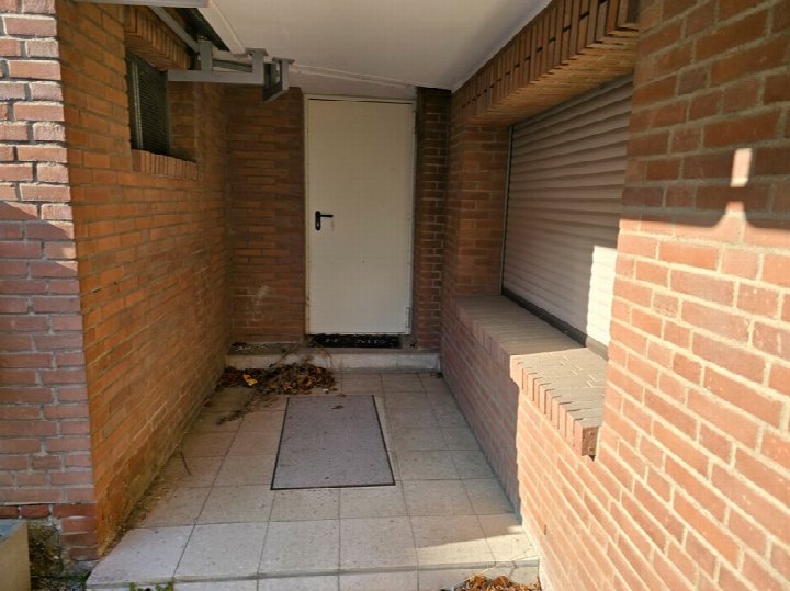 Eingangsbereich eines Einfamilienhauses mit weißer Tür, roten Ziegelwänden und Fliesenboden, Gielsdorfer Straße 22, Bonn