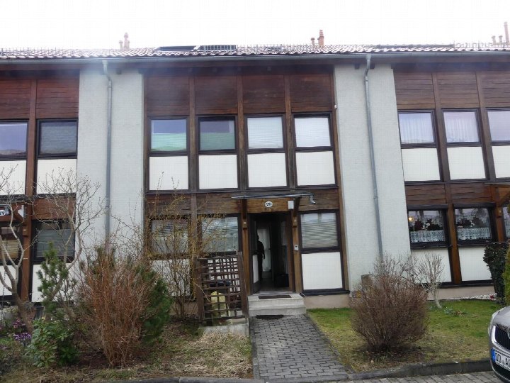 Eingangsbereich eines Reihenhauses mit Holzfassade, Eingangstür, Stufen und Vorgarten. Hausnummer 201, Dresden, Am alten Elbarm