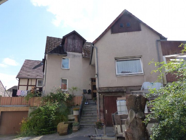 Rückansicht eines Einfamilienhauses mit Garten, Treppenaccess und angrenzenden Gebäuden in Bodenfelde, Braustraße 2