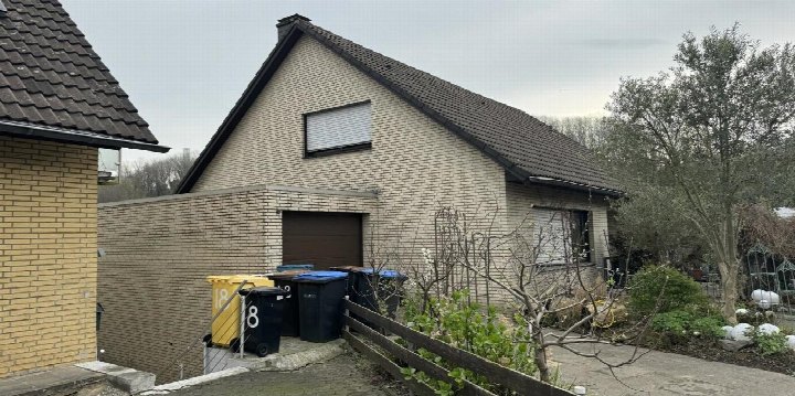Seitenansicht eines Einfamilienhauses mit Ziegelwand, Garagenzugang, Dach und Gartenbereich in Grevenbroich, Falkenstraße 16