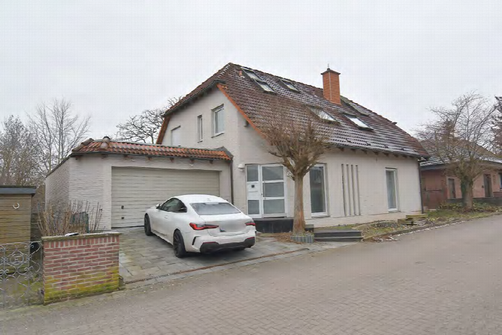 Weiße Limousine vor einer Garage an einem Einfamilienhaus in Sarstedt, Altes Dorf 4. Garagenstellplatz mit Ziegelmauer und Einfahrt