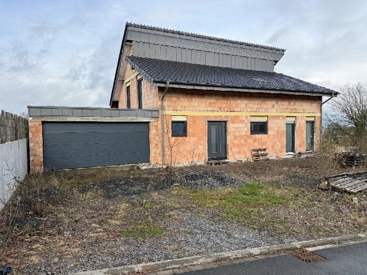 Einfamilienhaus in Arnsberg, An der Landstraße 17, im Rohbau mit Sicht auf Frontfassade, Garage und Eingangsbereich