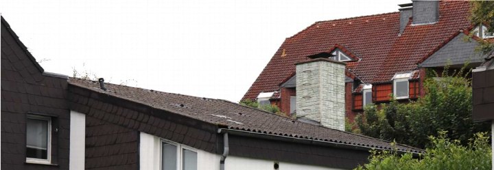 Dachansicht eines Einfamilienhauses mit braunen Dachziegeln, Schornstein und Dachgauben in Dortmund, Sichelstraße 57
