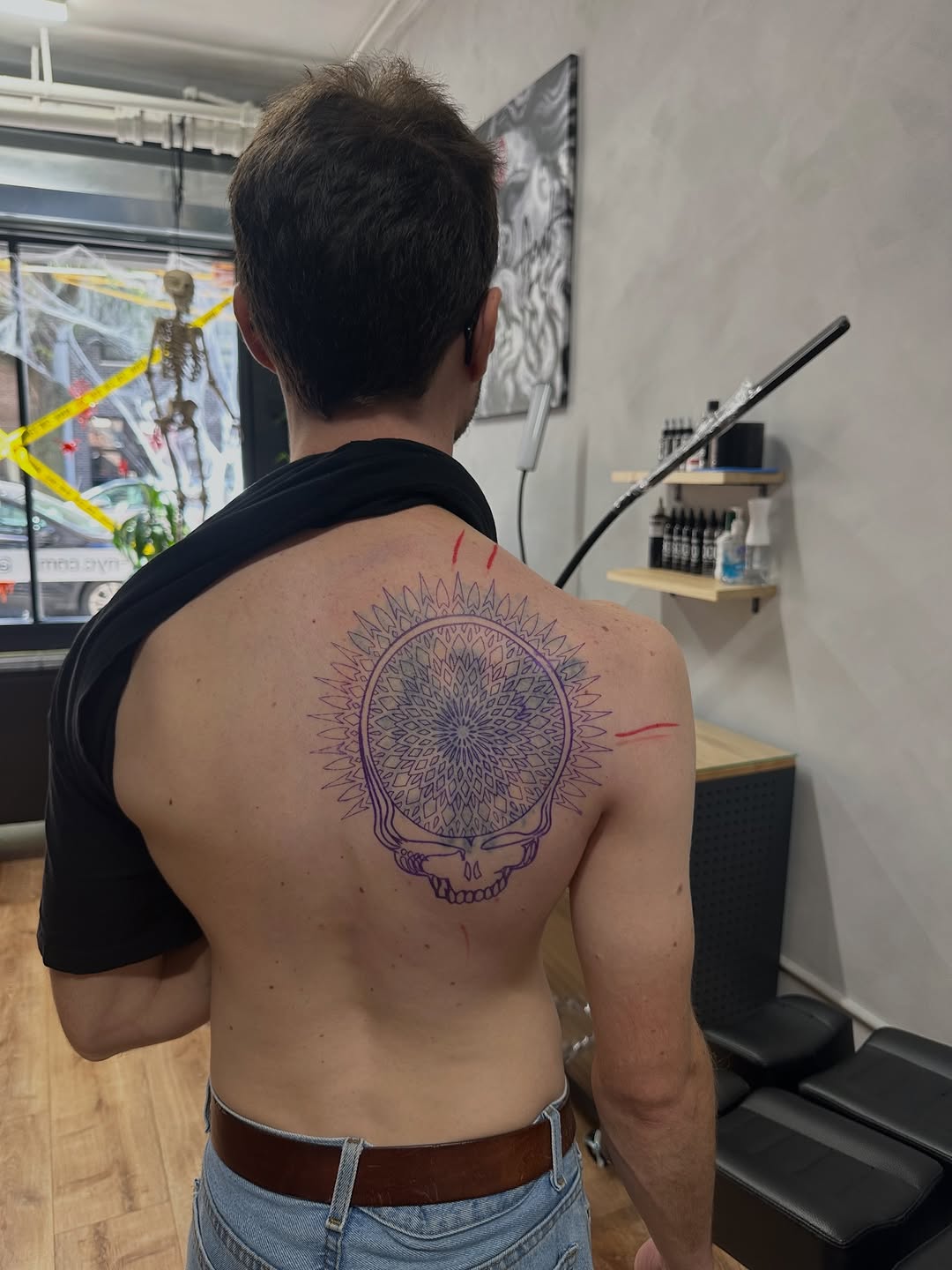 Intricate purple skull mandala on the upper back