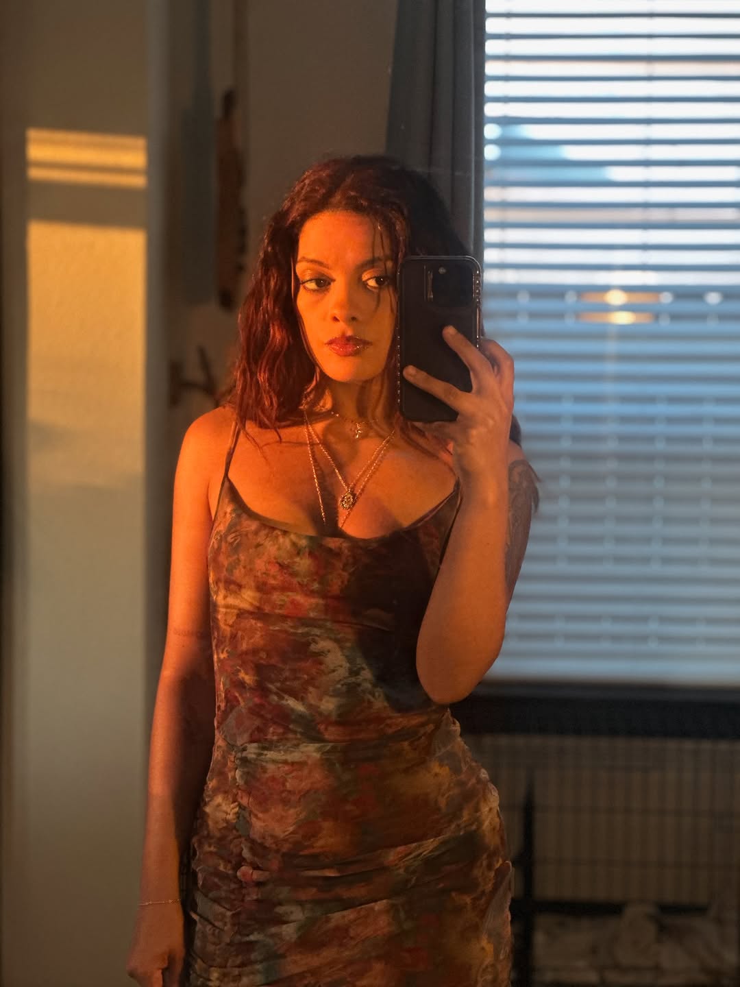 Soft-lit self-portrait highlighting subtle forearm tattoo