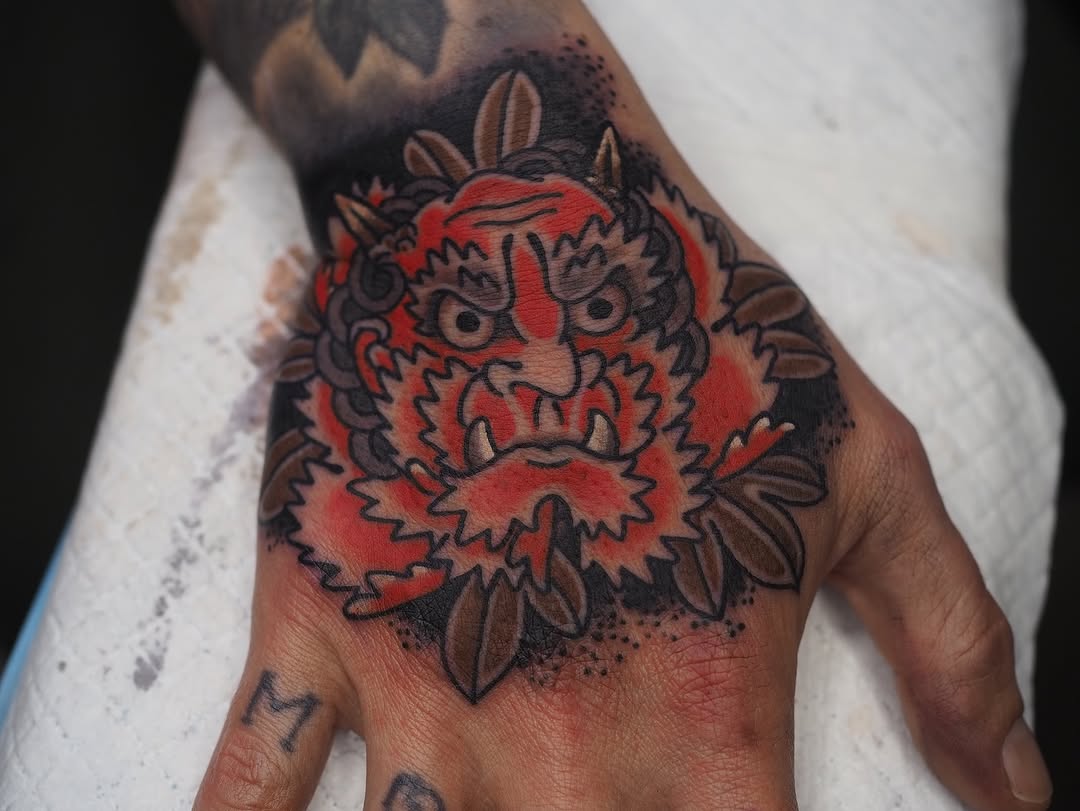 Fiery oni demon face with bold outlines and floral accents.