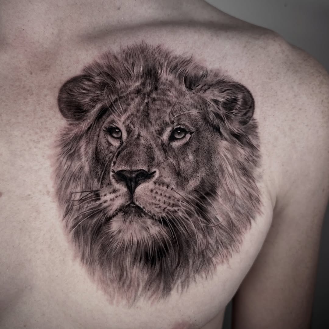 Hyper-detailed black-and-gray lion head on the chest.