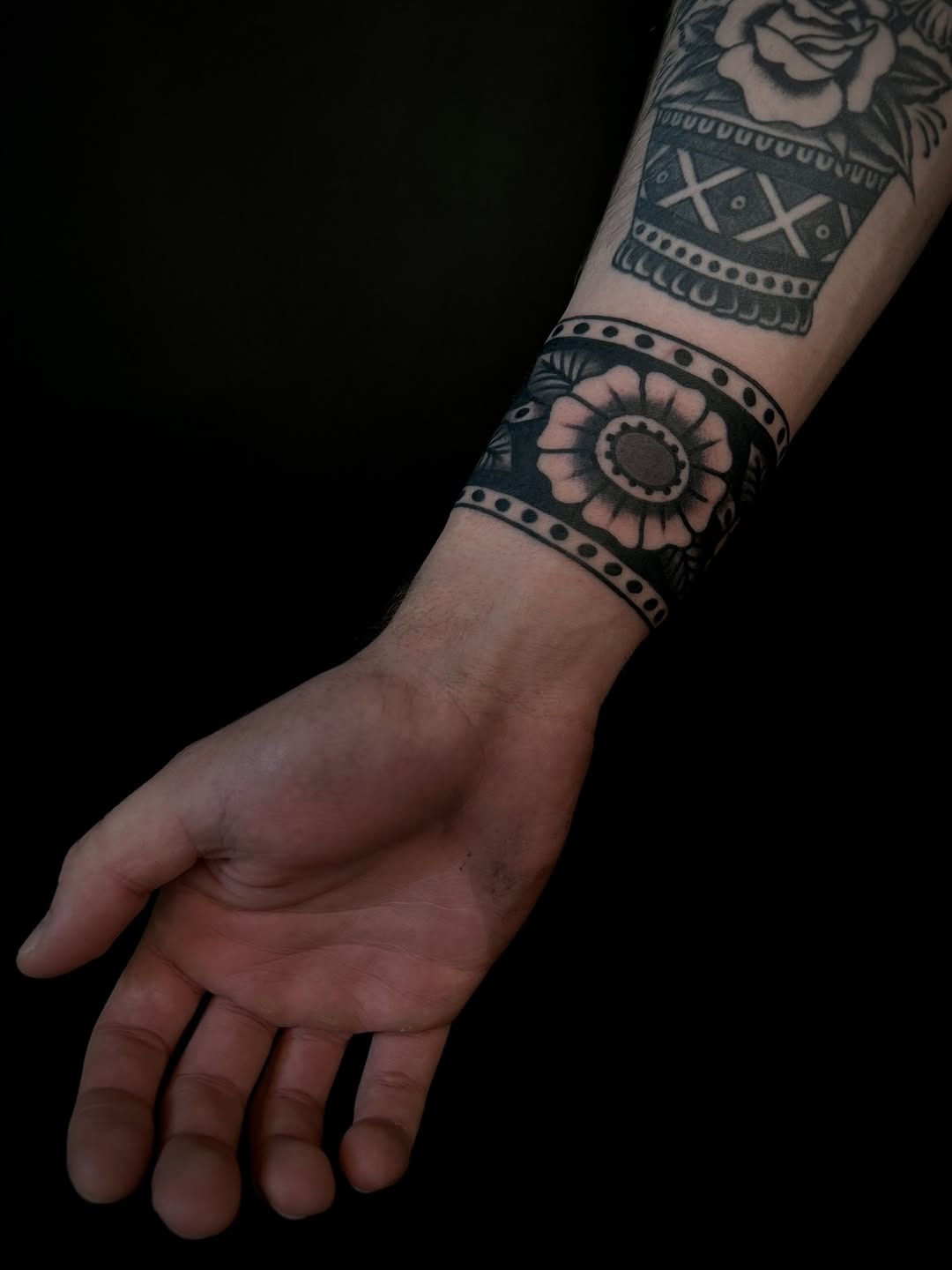 Bold blackwork banding with geometric motifs and floral ring