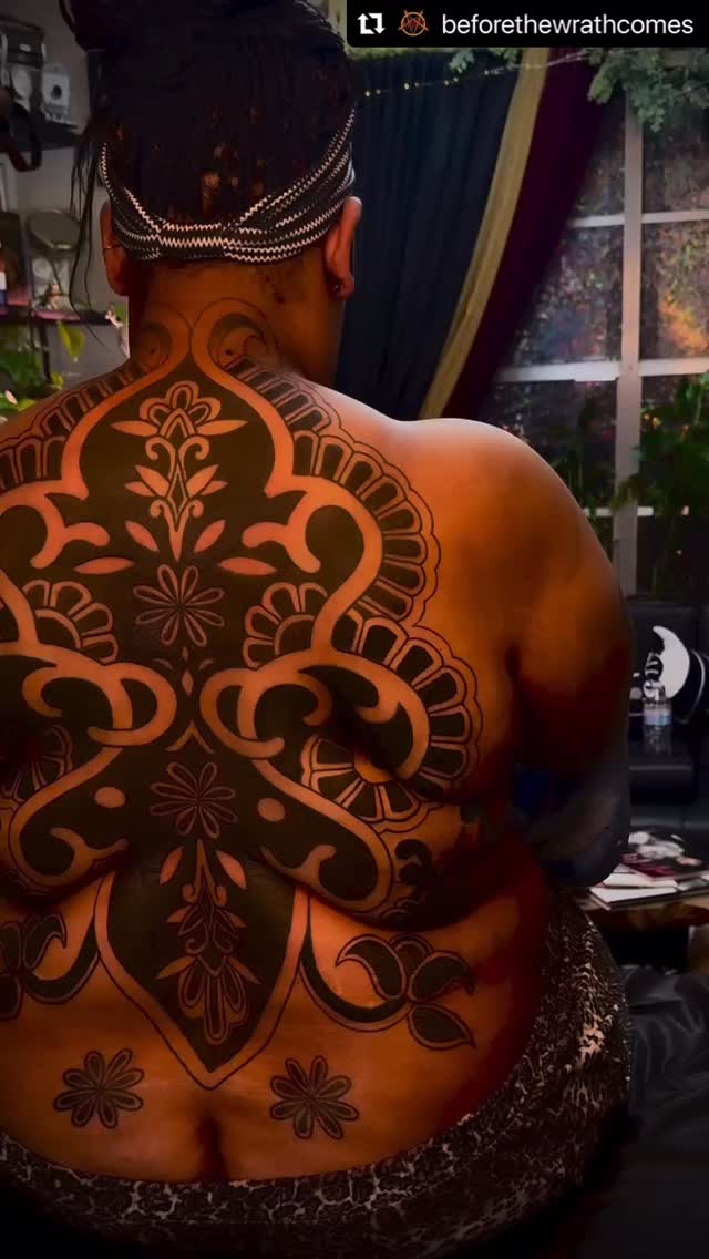 Intricate blackwork backpiece with bold ornamental filigree