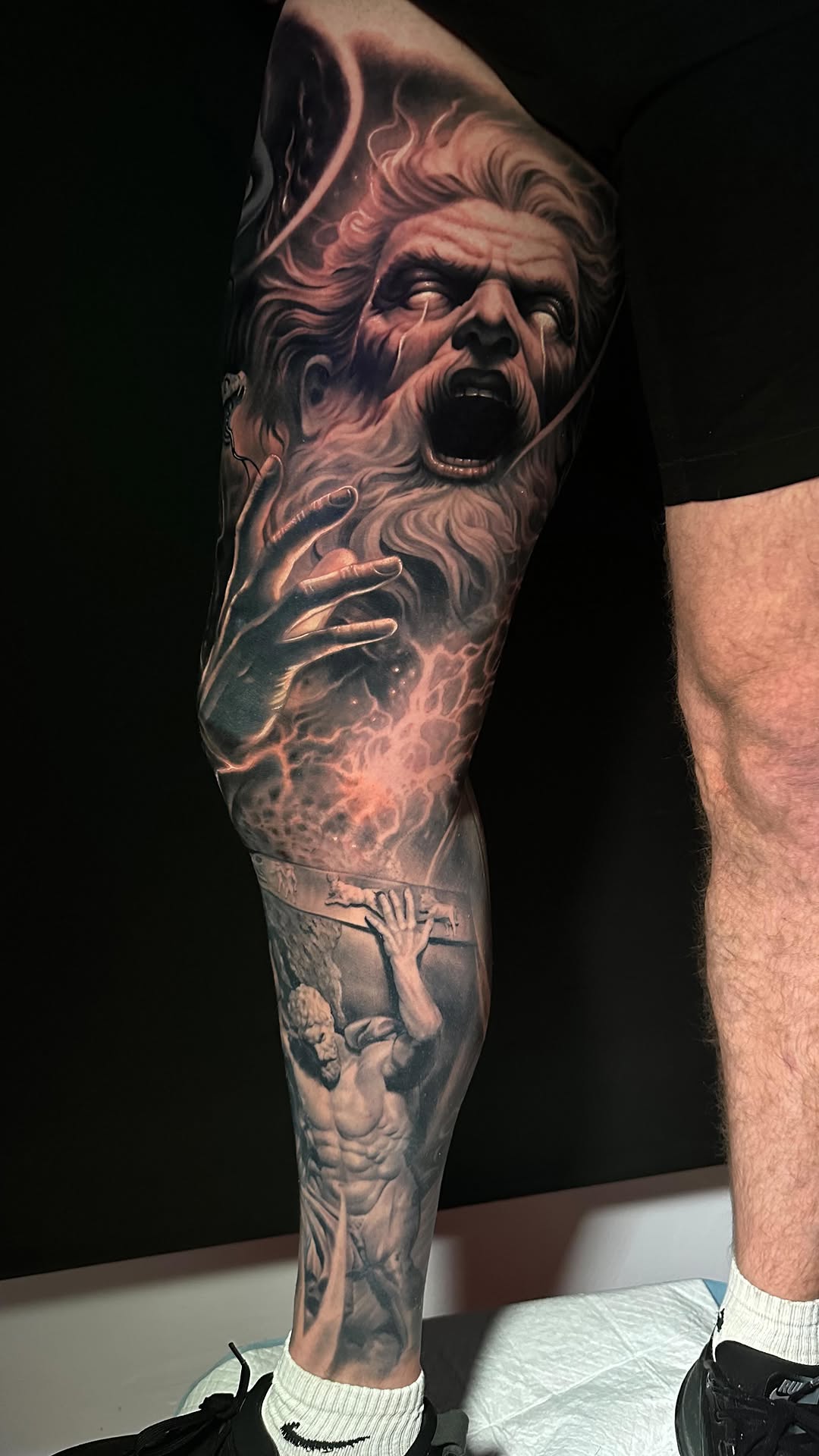 Dramatic black-and-gray Greek myth sleeve with ferocious figure