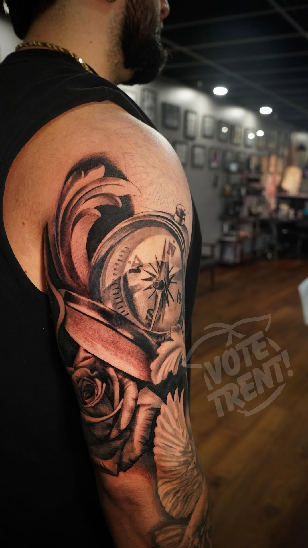 Bold black-and-gray compass rose entwined with roses.