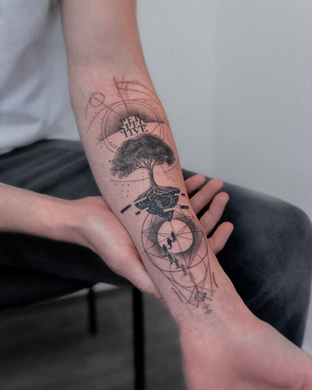 Geometric tree tattoo with circular arcs and fine lines.