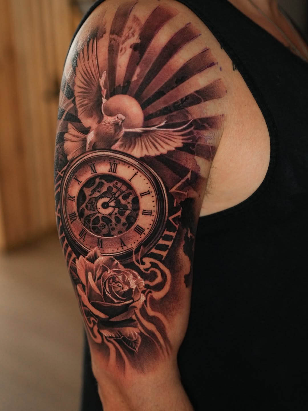 Intricate black-and-gray pocket watch with dove and rose