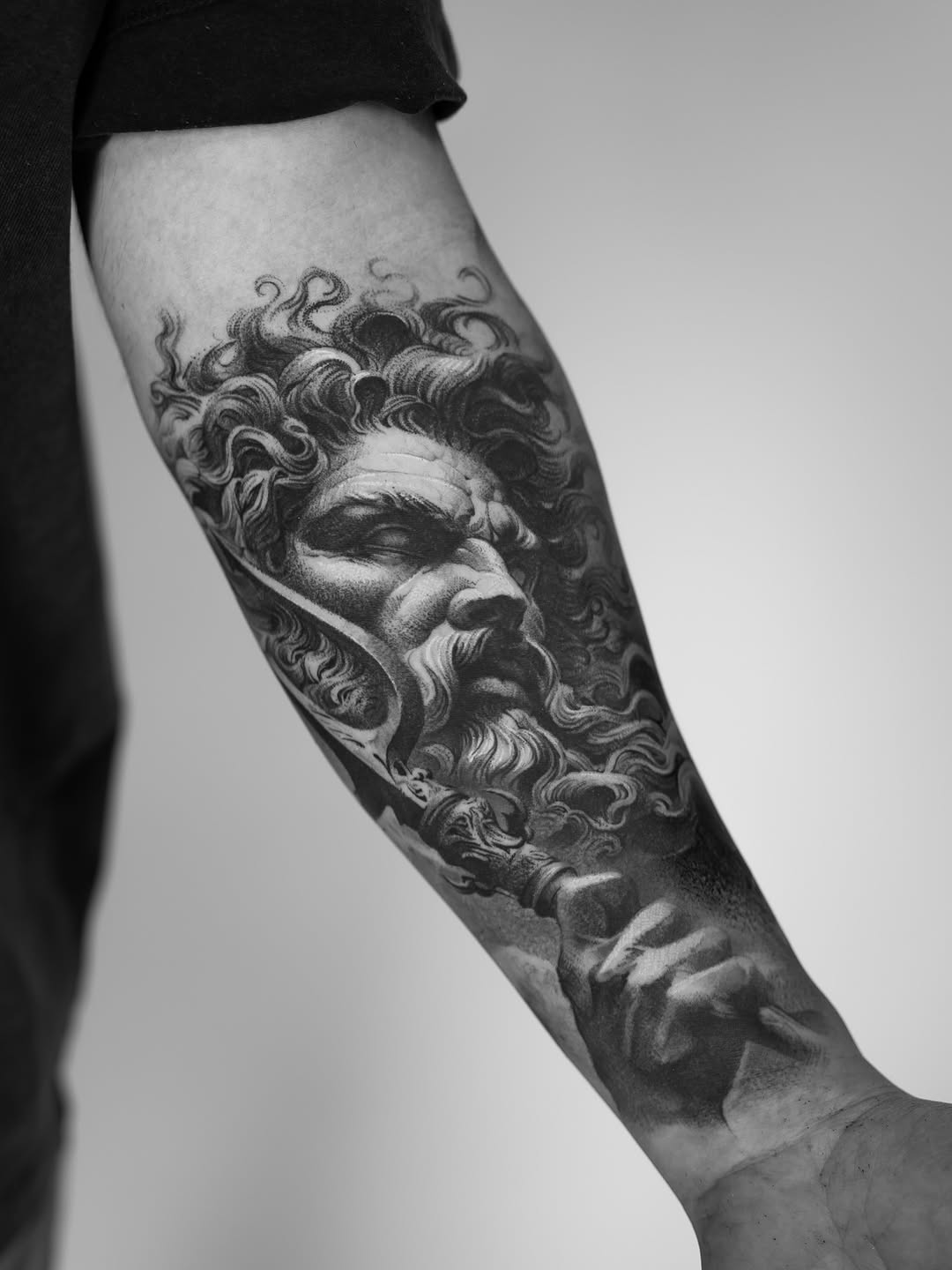 Healed Zeus tattoo on forearm