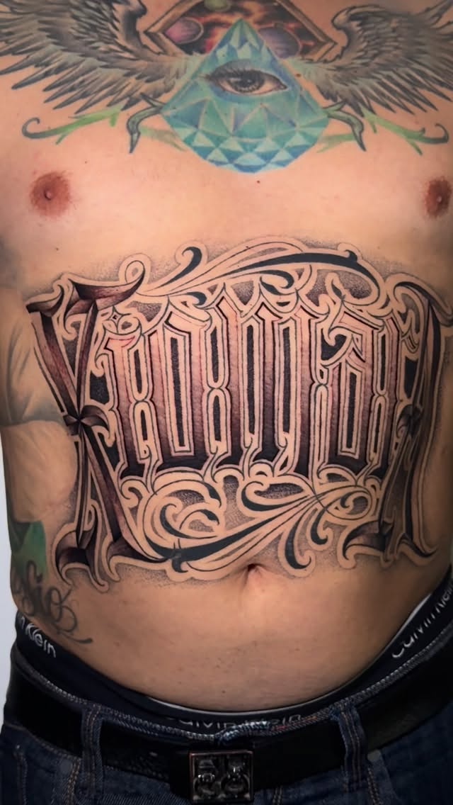 Ornate gothic lettering chest piece with flourishes