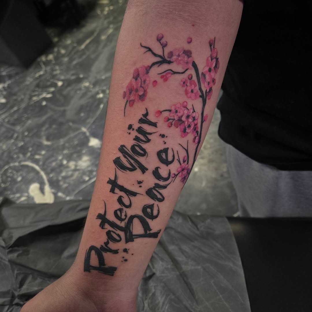 Bold brush-lettering phrase with delicate pink cherry blossoms