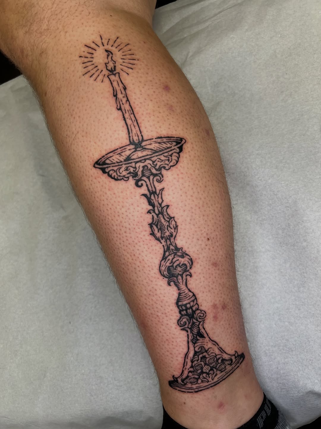 Ornate candleholder with vine-like stem in linework