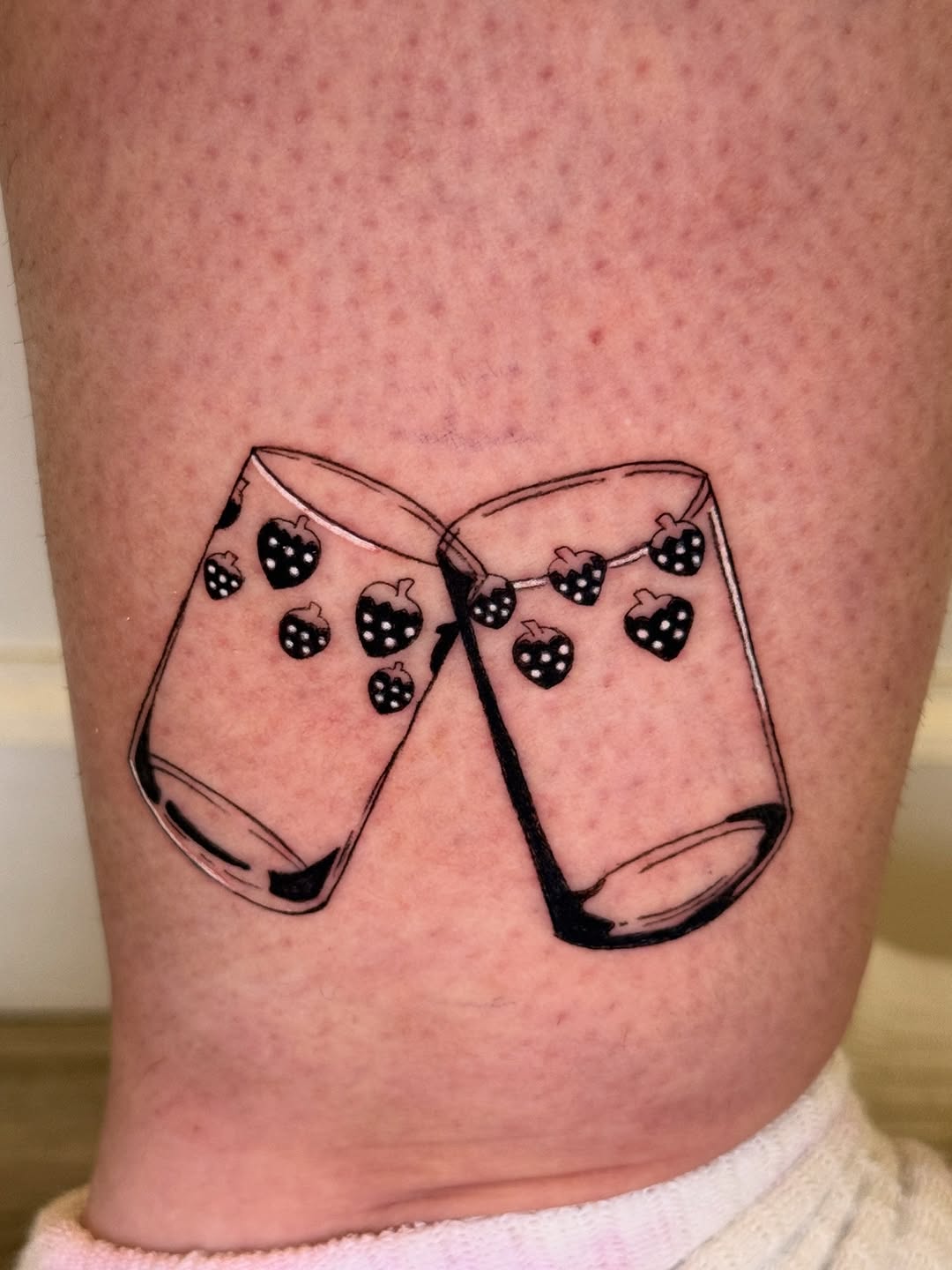 Bold linework of clinking glasses with berry garland