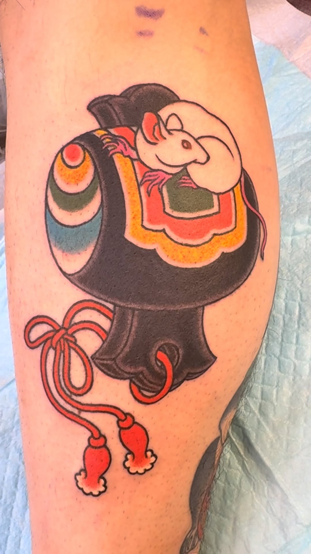 Bold cartoon mouse perched on a lacquered, tassel-draped vessel.