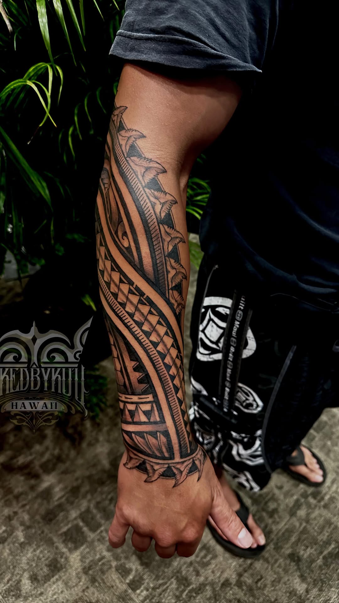 Ornate Polynesian blackwork forearm sleeve with bold geometrics