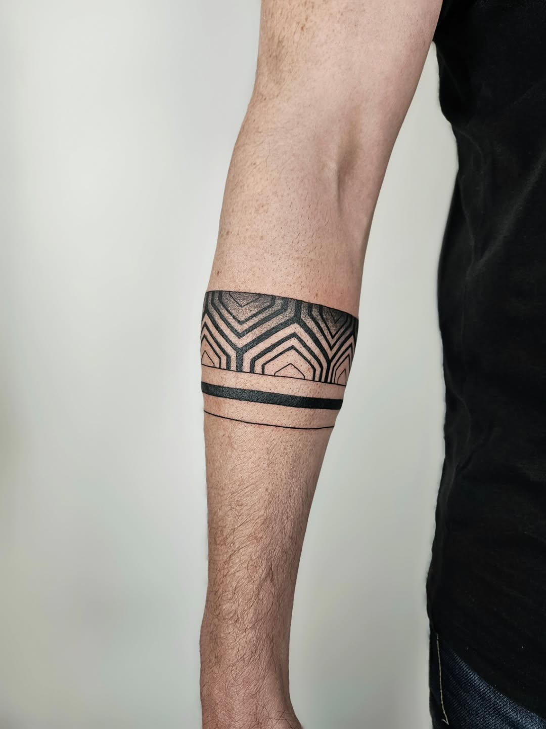 Bold geometric armband with crisp black-linework and chevrons