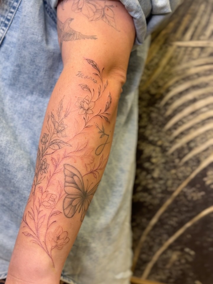 Delicate botanical vine with blooms and a butterfly accent