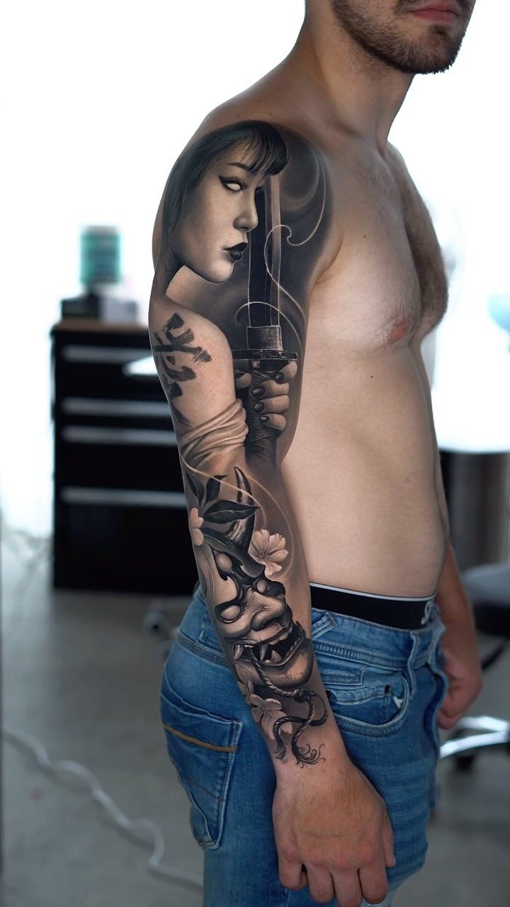 Grayscale realism full-sleeve with portrait and dagger.