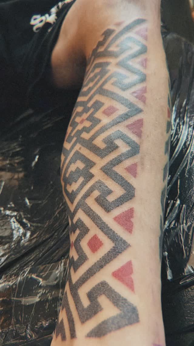 Bold dotwork geometric Moluccan ikat pattern on forearm