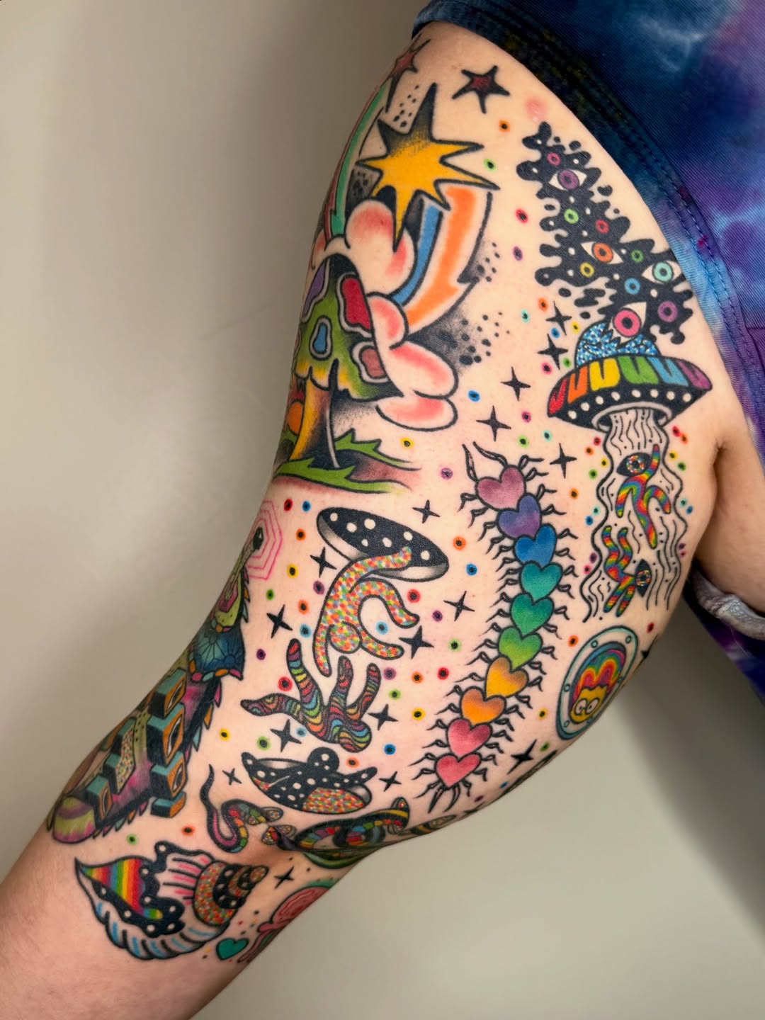 Vibrant, chaotic neon cartoon full-sleeve tattoo.