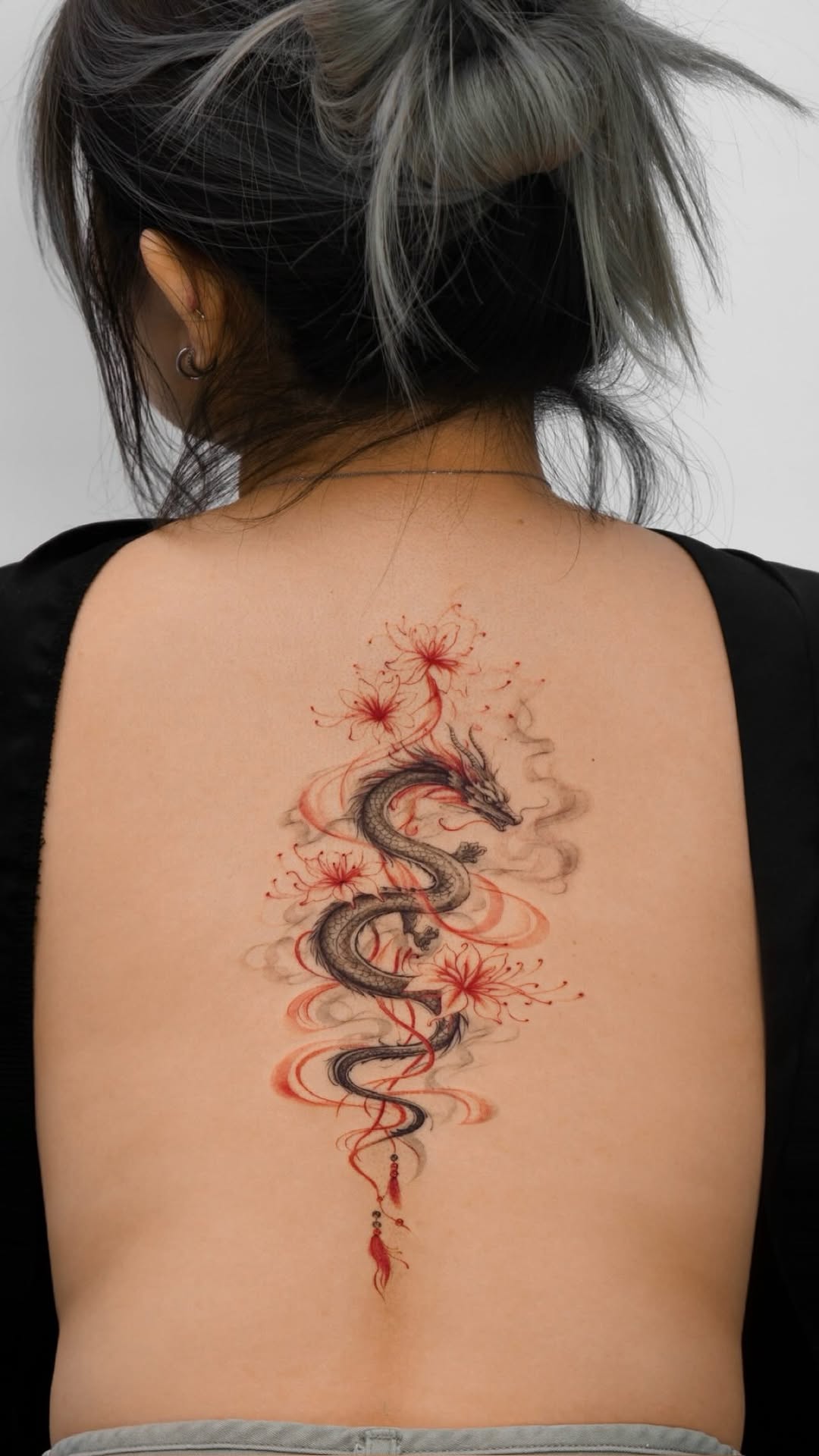 Elegant black dragon with red lilies and flowing wisps