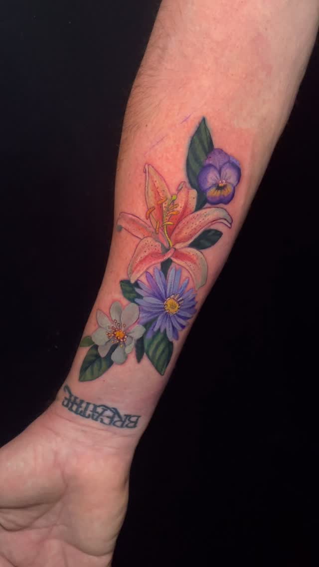 Vibrant bouquet of lilies and pansies on forearm