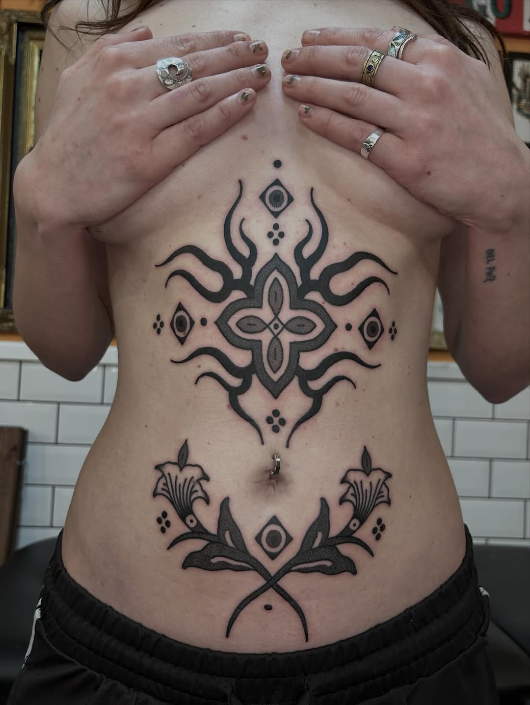 Intricate blackwork ornamental backpiece with symmetrical motifs.