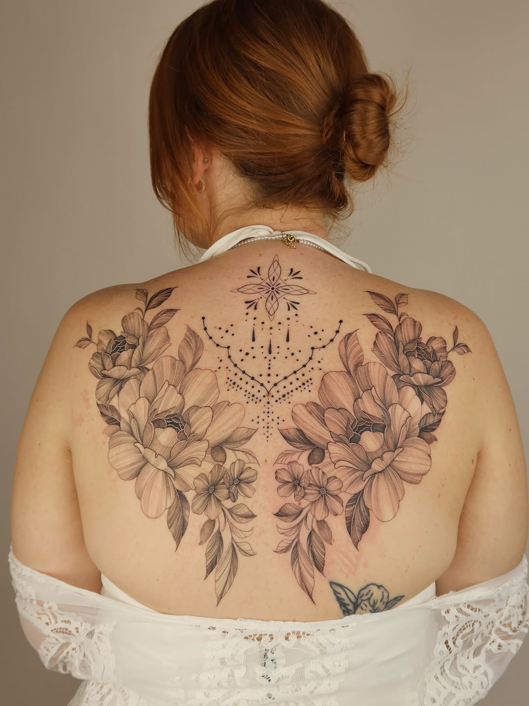 Delicate floral back piece with central geometric dotwork mandala