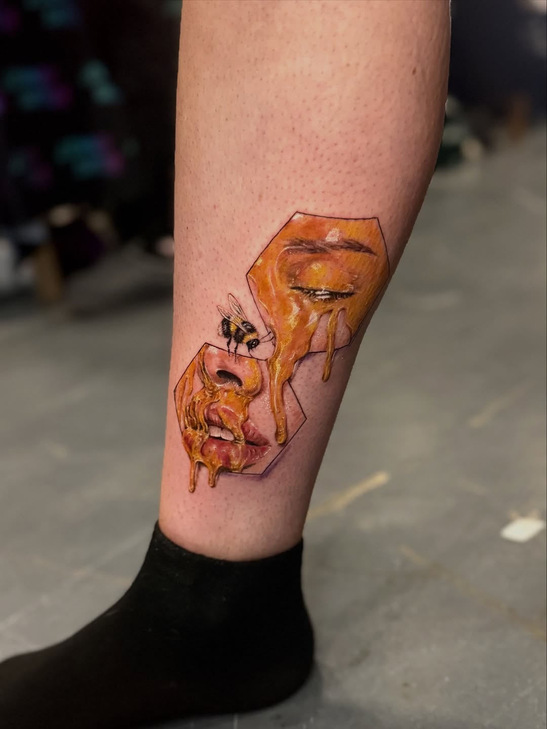 Vivid melting-face portrait framed by hexagons with bee