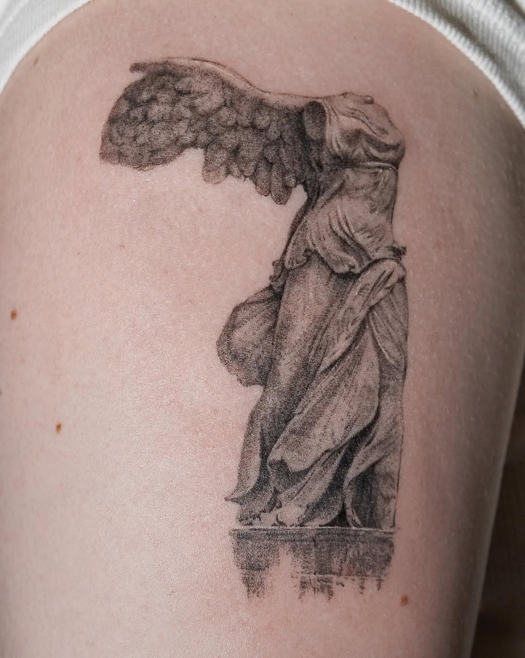 Classic draped statue with wings, shaded in grayscale