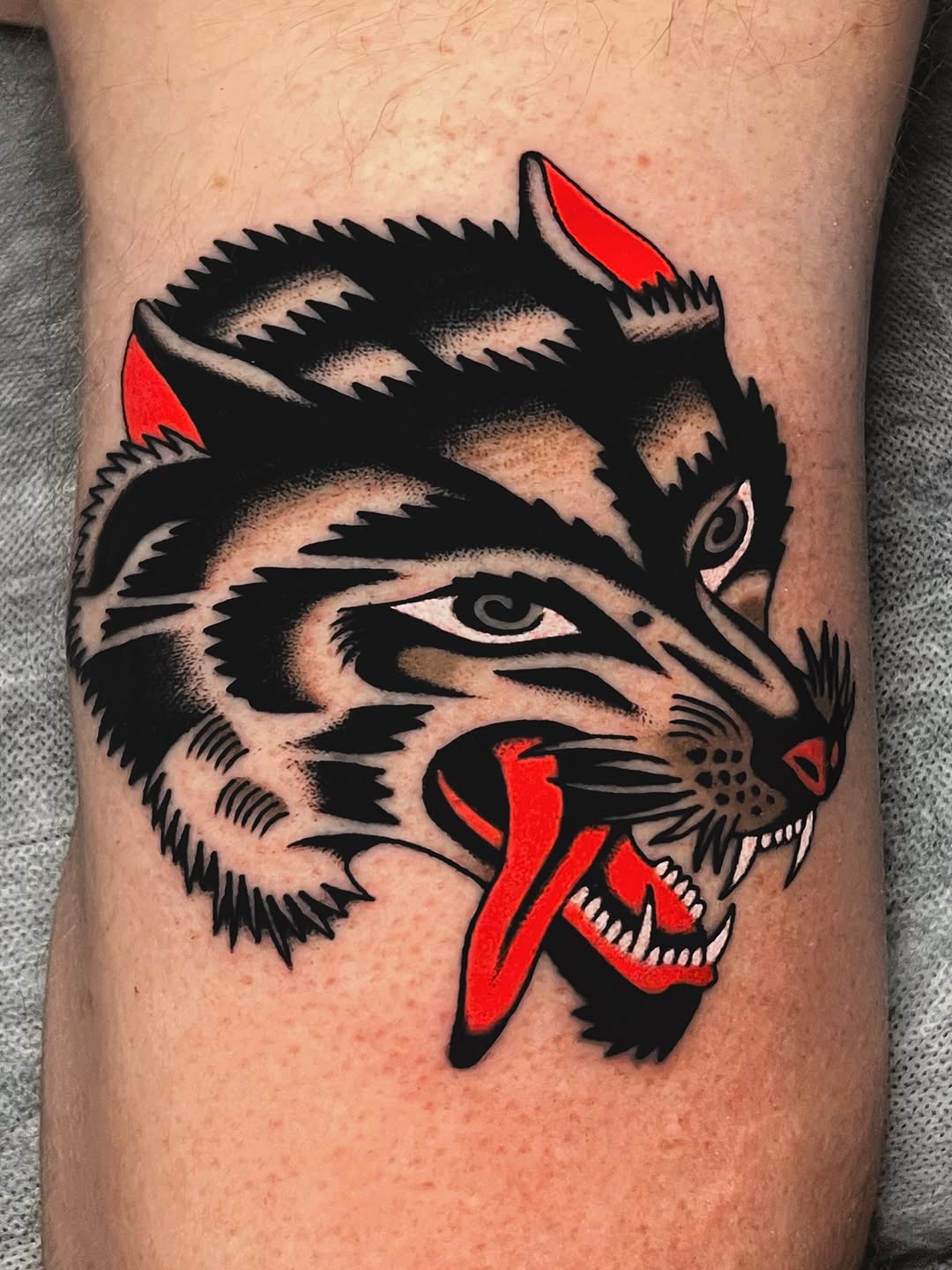 Bold snarling wolf head with thick black lines and red accents