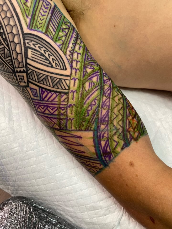 Vibrant polynesian-tribal forearm sleeve with bold geometric patterns