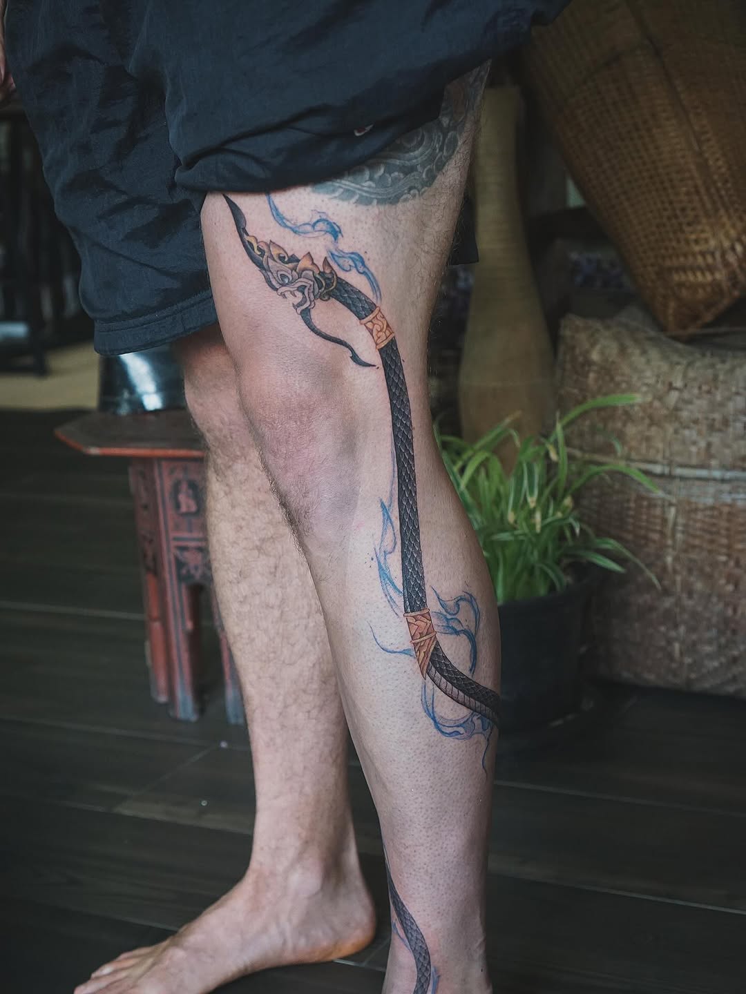 Thai naga serpent wrapped along leg with blue flame