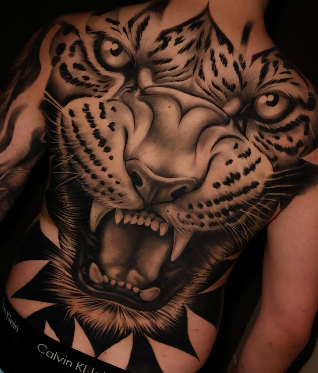 Monstrous black-and-gray leopard head roaring across chest