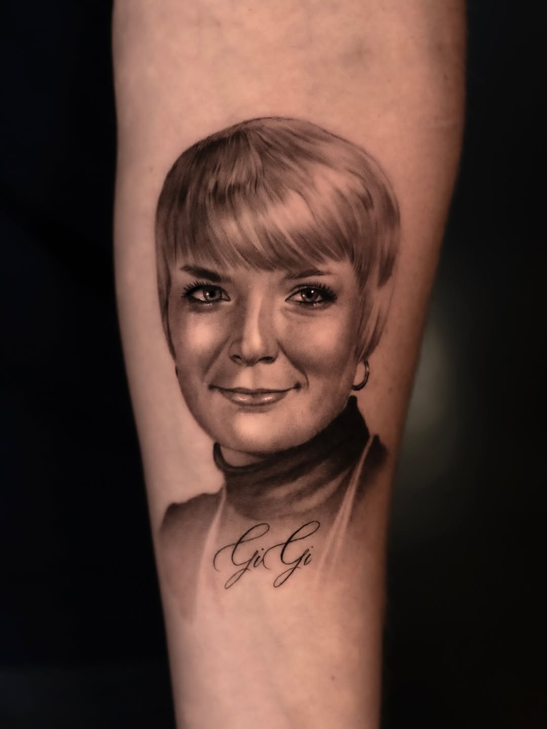 Hyper-realistic grayscale portrait of grandmother on forearm.
